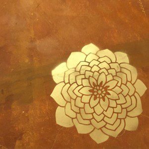 Use a stencil and gold spray paint to add a bright touch to your floor, by CraftyChica.com.