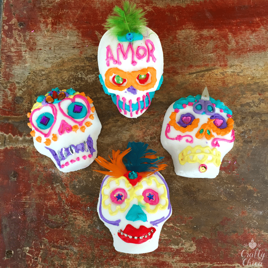 Colorful decorated sugar skulls with feathers, icing and gems.